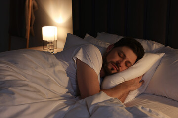 Canvas Print - Handsome man sleeping in bed at night