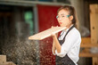 © EKKAPON - Female carpenter working in wood workshop. Female joiner wearing safety uniform and working in furniture workshop