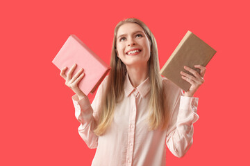 Wall Mural - Young woman with books on red background