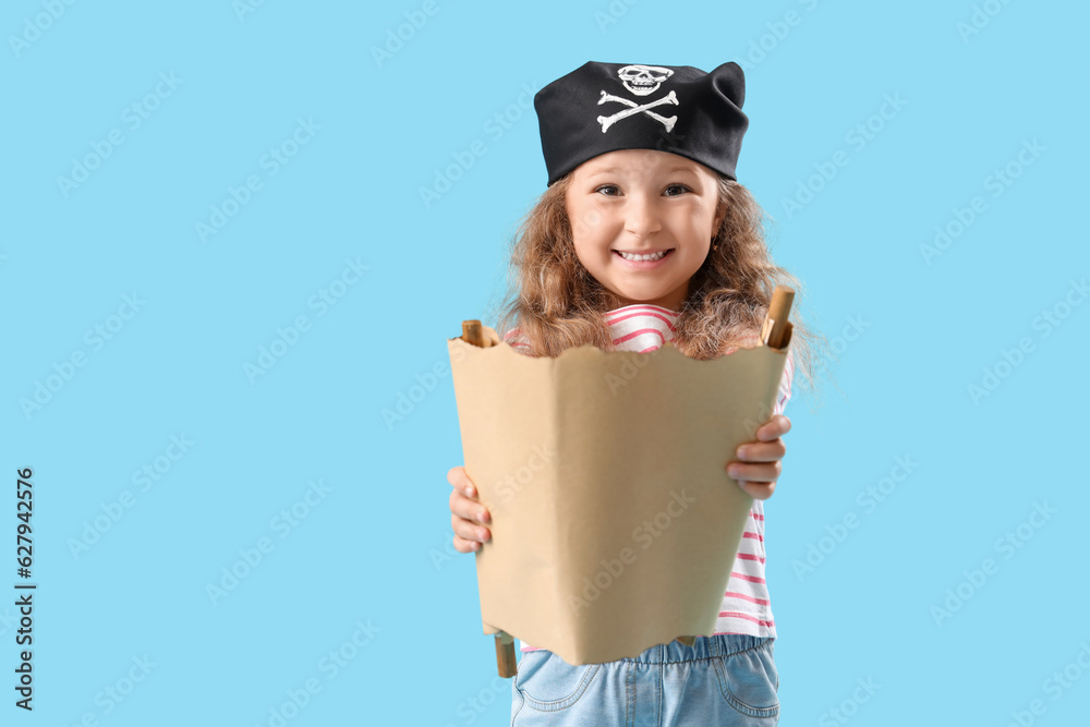 Cute little girl dressed as pirate with treasure map on blue background