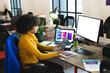 © wavebreak3 - Focused african american female designer using tablet and computer with copy space at desk in office