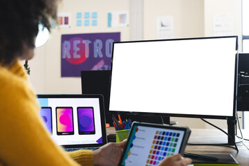 Fototapete - African american female designer using tablet and computer with copy space at desk in office