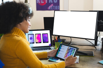 Fototapete - Happy african american female designer using tablet and computer with copy space at desk in office
