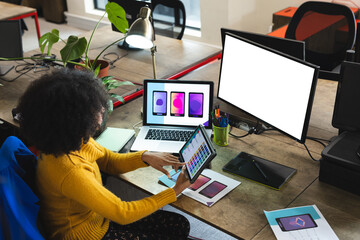 Fototapete - African american female designer using tablet and computer with copy space at desk in office
