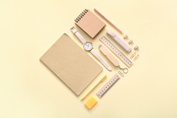 Different school stationery, notebooks and wristwatch on beige background