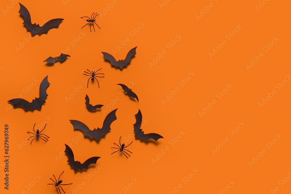 Paper bats and spiders for Halloween party on orange background