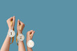 © Pixel-Shot - Female hands with medals on blue background