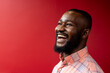 © Wavebreak Media - Side profile view of african american businessman smiling against red background, copy space