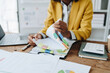 © Jirapong - financial, Planning, Marketing and Accounting, portrait of african american employee checking financial statements using documents and calculators at work