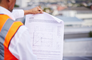 Canvas Print - Construction site, blueprint and man reading document of building proposal in city from the back. Closeup design of floor plan, project or architecture for industrial development in civil engineering