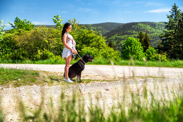 Wall Mural - Girl with black dog waiting on the road