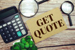 Get Quote text message with calculator and magnifying top view on wooden background