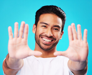 Poster - Portrait, hands and man frame face in studio to review profile picture on blue background. Happy young asian model planning perspective of photography, selfie and creative inspiration for border sign