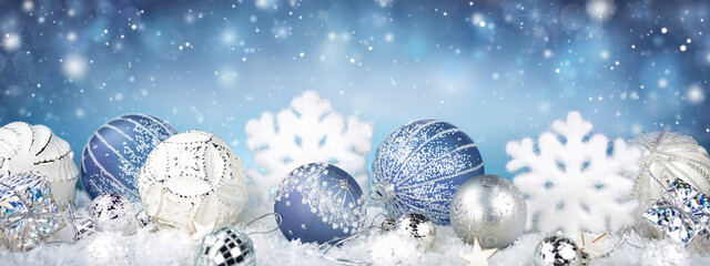 Poster - Winter snowy background with Christmas toys, snowdrifts, with beautiful light and snow flakes on the blue sky in the evening, banner format, copy space. Christmas decoration.