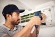 © Malik/peopleimages.com - Maintenance, air conditioning service and man with drill, working on ventilation filter or ac repair. Contractor, handyman or electric aircon machine expert problem solving cleaning dust and tools.