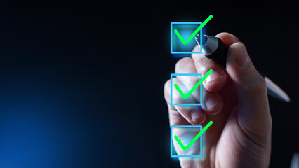 Digital checkbox. Man's hand puts ticks. Checkbox on invisible screen. Concept planning. Checkbox for tracking processes. Green ticks on dark background. Metaphor for planning your own time