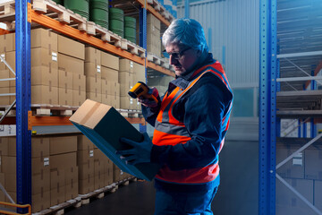 Poster - Man is storekeeper. Warehouse worker. Guy with box and scanner. Laser barcode scanner. Terminal for data collection. Gray-haired man is storekeeper. Supervisor near multi-tier warehouse racks