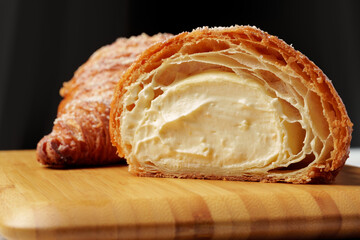 Wall Mural - Freshly baked croissant with powdered sugar on wooden board