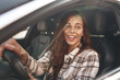 © fotofabrika - Young smiling woman driving a car in the city