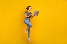 Full Length Photo Of Funky Pretty Girl Dressed Khaki Top Jumping Writing Modern Gadget Empty Space Isolated Yellow Color Background