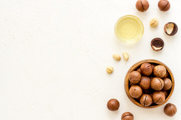 Wall Mural - Bowl of of macadamia nuts oil with raw nuts. Natural oil for cosmetic or cooking