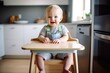 shot of an adorable baby boy sitting in his high chair at home