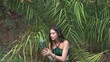 © Maksim - A young woman holding a pineapple against a jungle background