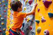 Little boy climbing on a climbing wall indoors. Healthy lifestyle concept.