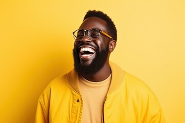 Portrait of a smiling fictional black model with a beard and glasses. Isolated on a bright yellow colored background. Generative AI.