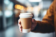 © colnihko - Man's hand holding takeaway paper coffee cup mock up