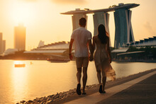 Young Couple Traveling And Walking In Singapore. City In Background. Man And Woman View From Behind. Sunset Summer Background. Generative AI