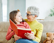 © Lumos sp - grandchild family child grandparent grandmother book reading elderly granddaughter girl  happy together read learning education woman