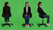 © DC Studio - Caucasian businesswoman wearing suit and sitting on chair, waiting in preparation over full body green screen backdrop. Young adult working as corporate employee being positive in studio.