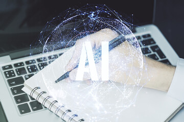 Poster - Creative artificial Intelligence symbol concept with hand writing in diary on background with laptop. Double exposure