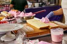Detail Of Baker Spreading Strawberry Frosting Over Cake To Create Layered Cake In Latin Market Bakery.