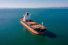 Bulk Vessel For Dry Cargo In Anchorage In Sea Waiting Loading In Industrial Port Aerial Shot
