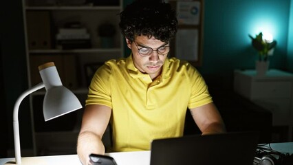 Poster - Young latin man business worker using computer and smartphone at the office