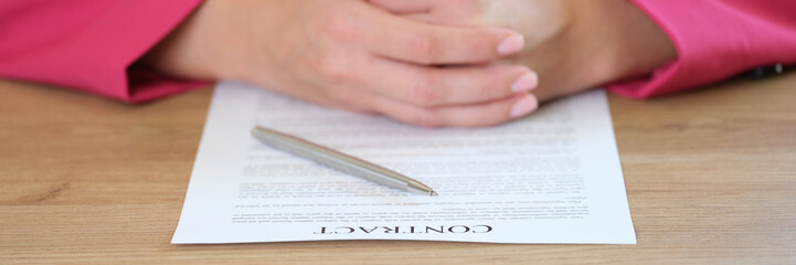 Wall Mural - Female manager is sitting at her office desk with contract paper and pen close-up.