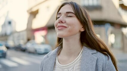 Poster - Young hispanic woman smiling breathing at street