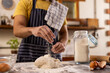 © Wavebreak Media - Midsection of indian man in apron preparing bread dough in sunny kitchen at home