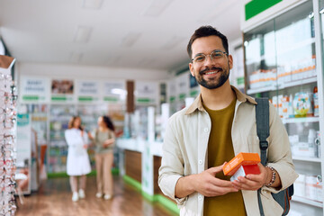 Poster - Happy man buying medicine in pharmacy and looking at camera.