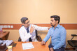 © PRASANNAPIX - Indian male doctor talking with patient at clinic.