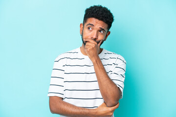 Wall Mural - Young Brazilian man isolated on blue background having doubts and with confuse face expression