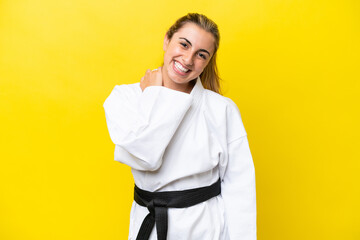 Young caucasian woman doing karate isolated on yellow background laughing