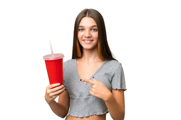 Poster - Teenager caucasian girl holding a soda over isolated background and pointing it