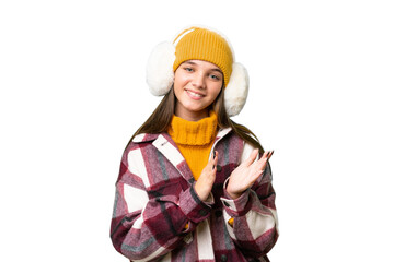 Poster - Teenager caucasian girl wearing winter muffs over isolated background applauding after presentation in a conference