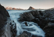 © ADDICTIVE STOCK - Rocky coast with waterfall against snowy mountain and sky