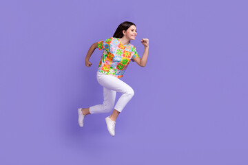 Sticker - Full size photo of good mood active person wear stylish t-shirt white pants running to empty space isolated on purple color background