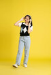 fullbody image of asian girl standing and posing  on yellow background