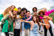Leinwandbild Motiv Happy playful multiethnic group of young friends bonding outdoors - Multiracial millennials students meeting in the city, concepts of youth, people lifestyle, diversity, teenage and urban life